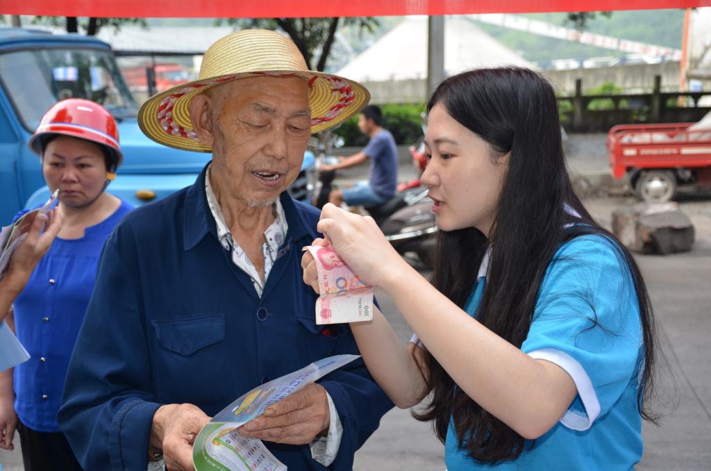 实践团成员教社区群众辨别假币